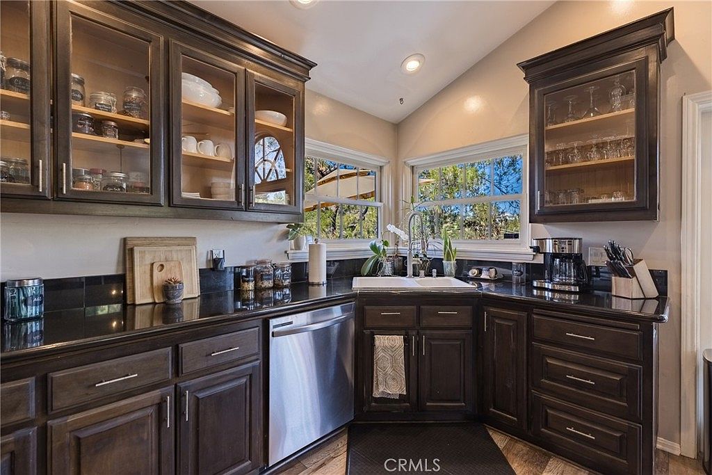 Kitchen with glass-front dark cabinetry, granite countertops, and mountain window views